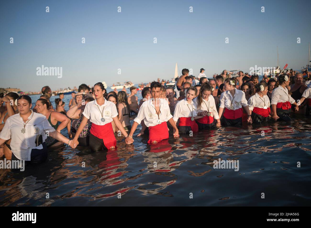 Malaga, Spanien. 16.. Juli 2022. Büßer der Bruderschaft Virgen del Carmen treffen sich am Strand, während sie an der Prozession „Virgen del Carmen“ im Viertel „El Palo“ teilnehmen. Jedes Jahr, am 16. Juli, feiert die Stadt Málaga ein religiöses Fest zu Ehren der Virgen del Carmen, der Schutzpatronin der Segler und Fischer. Die Statue der Jungfrau, die von einer Gruppe von Gläubigen in traditioneller Tracht entlang der Straßen getragen wird, wird auf einem Boot vom Strand aufgestellt, das später die Küste Malagas hinunter segelt. Kredit: SOPA Images Limited/Alamy Live Nachrichten Stockfoto