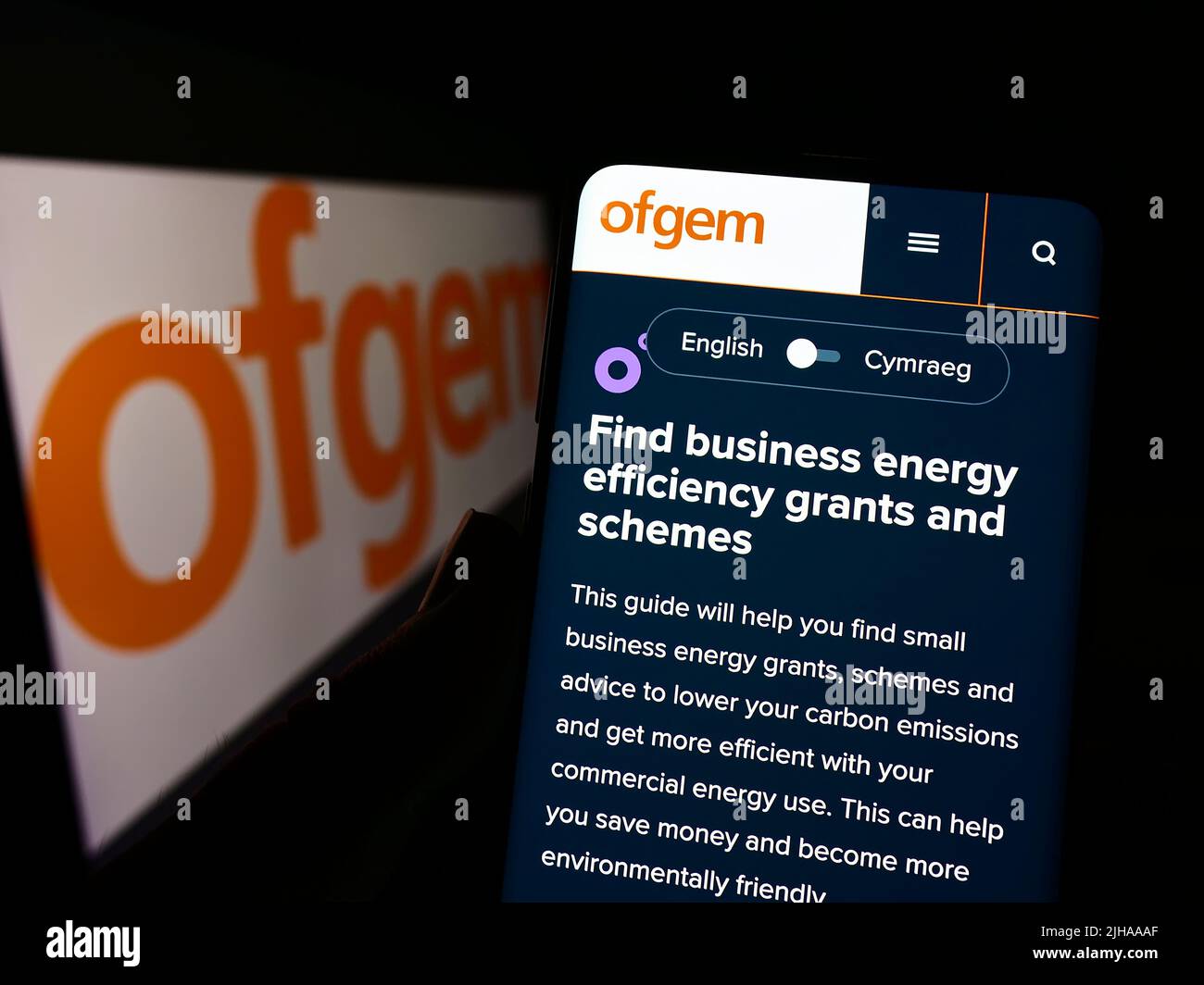 Person, die Mobiltelefon mit Website des Amtes für Gas- und Elektrizitätsmärkte (Ofgem) auf dem Bildschirm mit Logo hält. Konzentrieren Sie sich auf die Mitte des Telefondisplays. Stockfoto