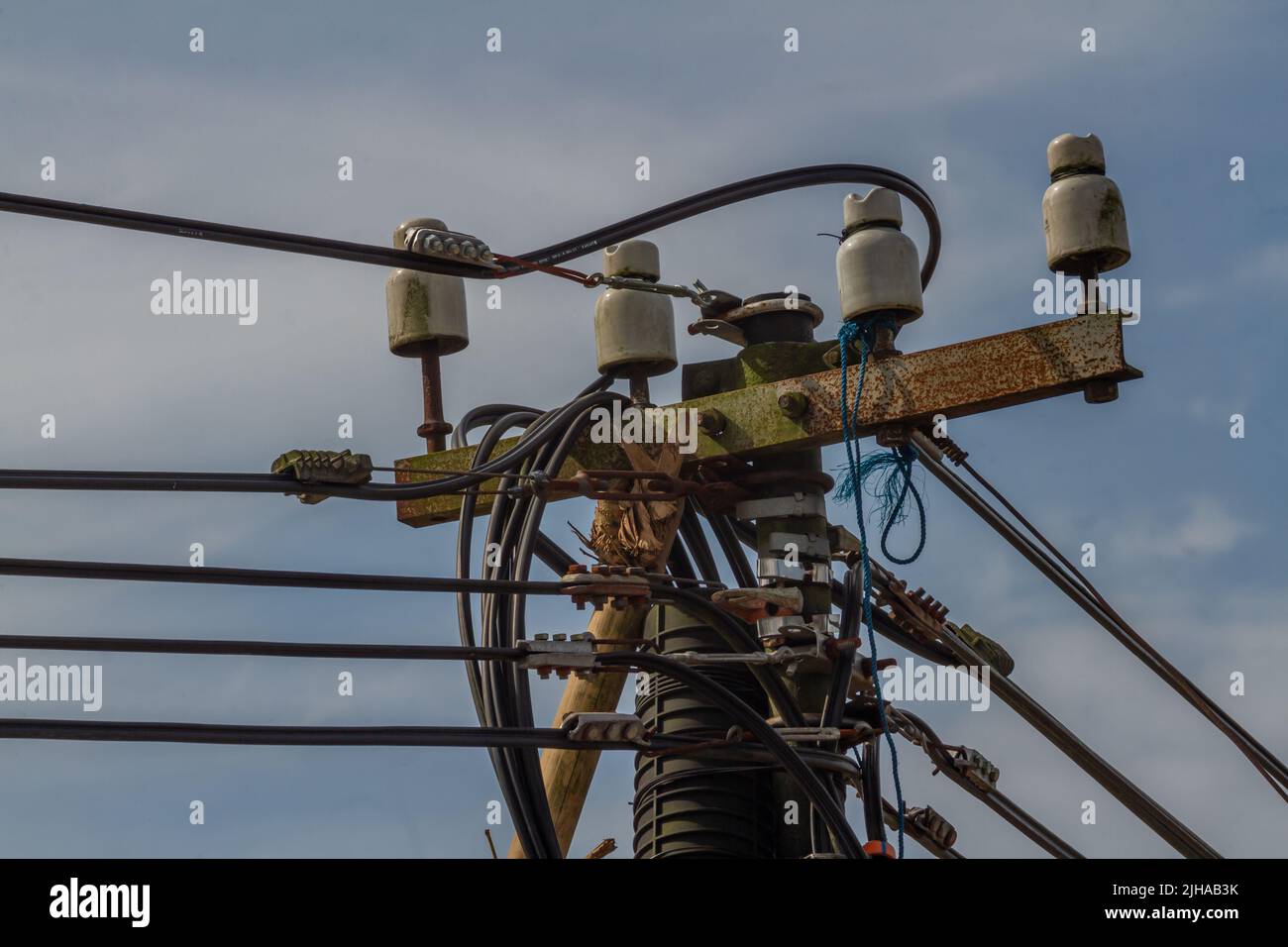 Der Bedarf an Energieressourcen steigt, da es sich um einen Strommast mit komplizierter Kabelanordnung handelt Stockfoto