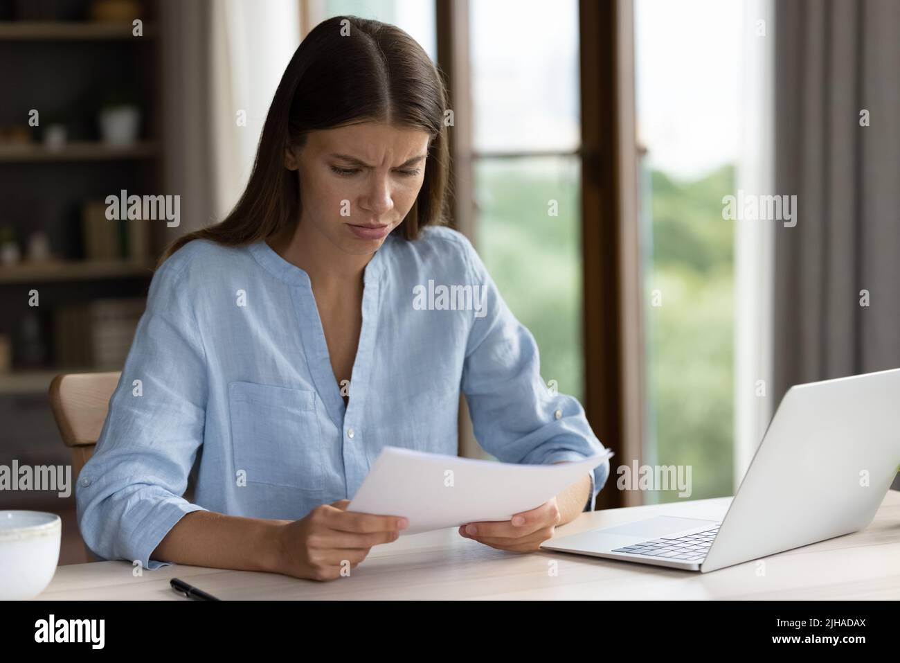 Frau lesen Brief mit schlechten Nachrichten sieht unzufrieden Stockfoto