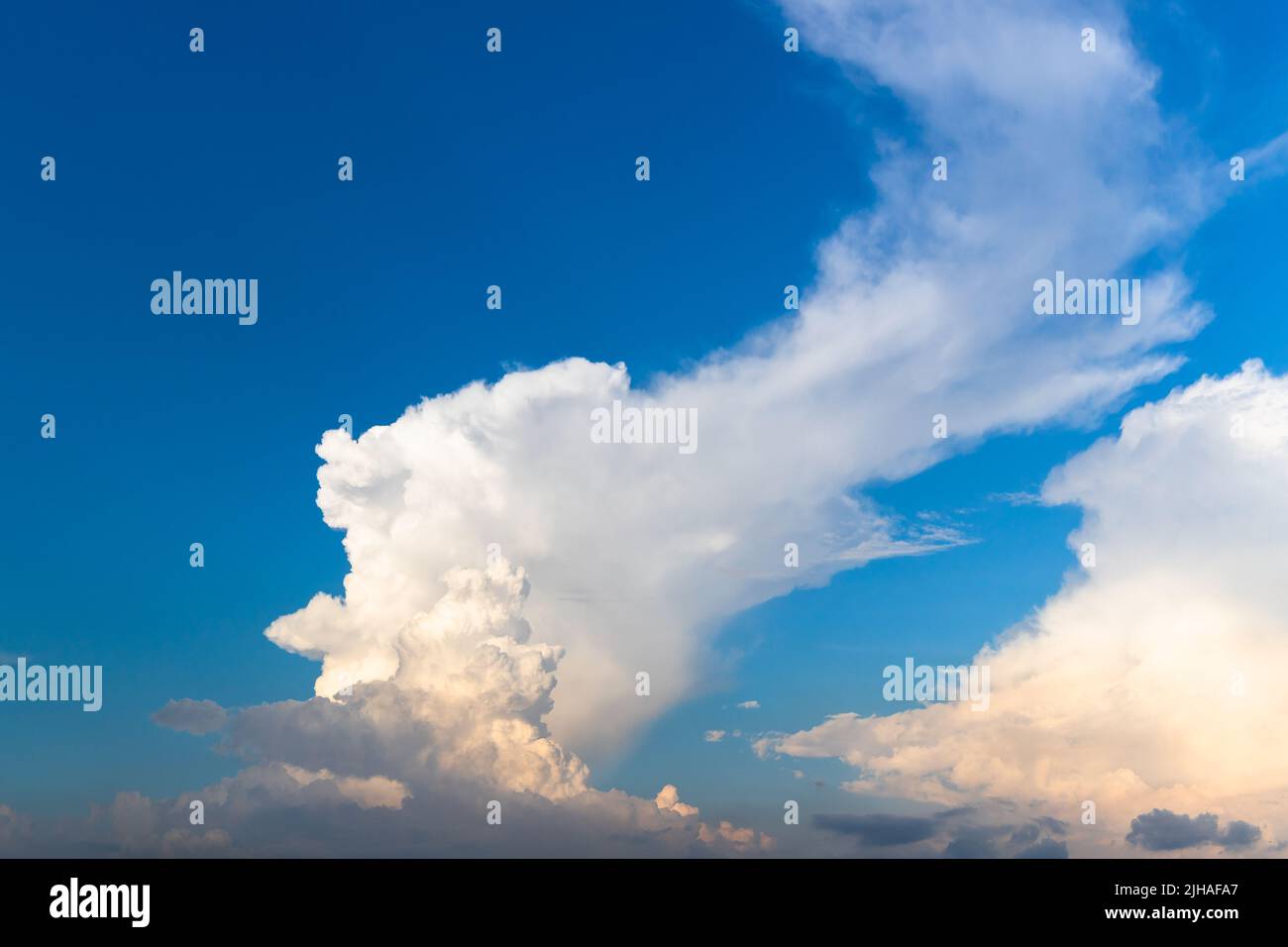 Weiße Wolken sind in einem blauen Abendhimmel. Natürliches Hintergrundfoto Stockfoto