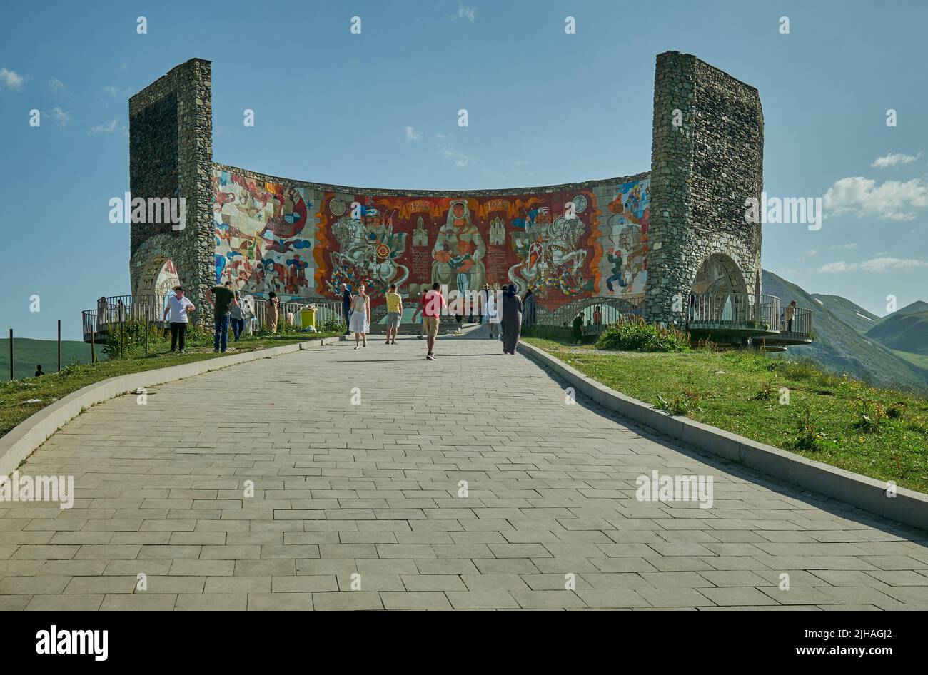 Russland-Georgien-Freundschaftsdenkmal in Gudauri, Georgien Außenansicht von Tageslicht mit wandelenden Besuchern und Wolken am Himmel im Hintergrund Stockfoto