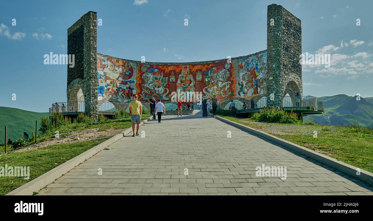 Russland-Georgien-Freundschaftsdenkmal in Gudauri, Georgien Außenansicht von Tageslicht mit wandelenden Besuchern und Wolken am Himmel im Hintergrund Stockfoto