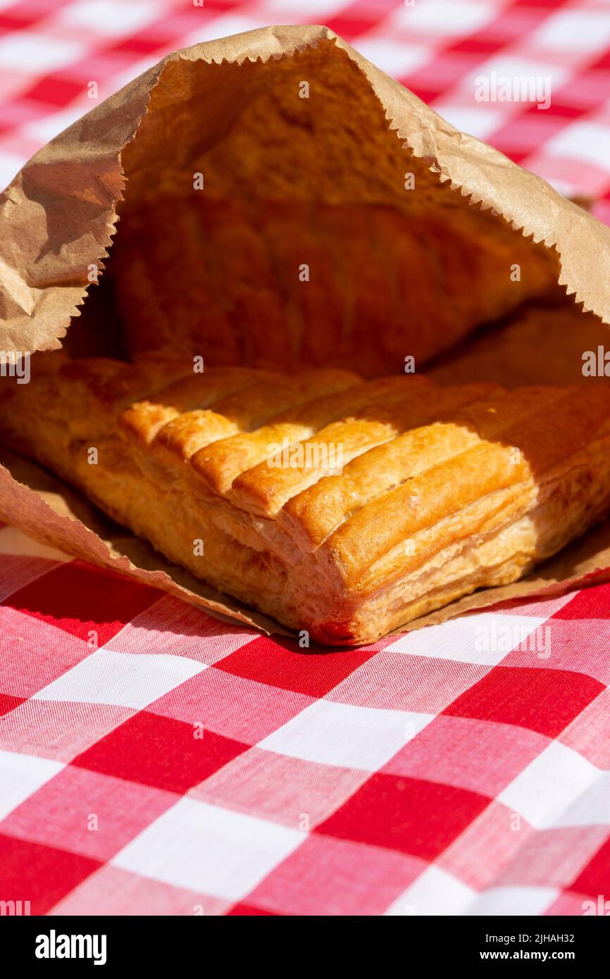 Apfelumschlag in einer braunen Papiertüte im Freien auf einem kargen Tuch. Umweltfreundliche Recycling-Verpackungen Stockfoto