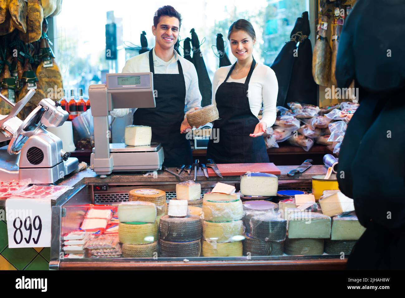 Zwei Arbeiter, die Käse und Wurst verkaufen Stockfoto