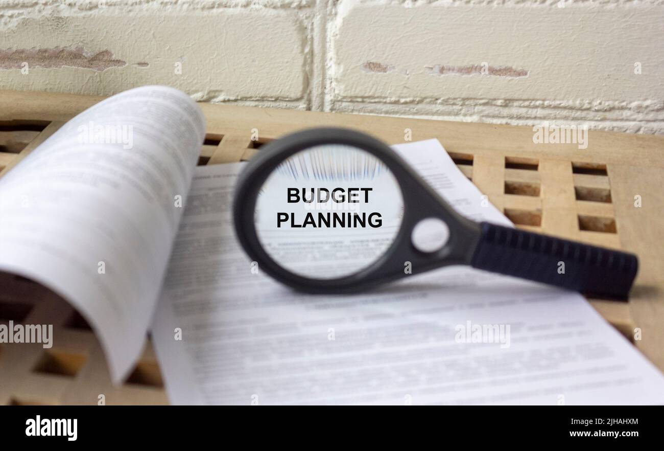 Planung monatlicher Budgettext durch Lupe auf Dokumenten Stockfoto