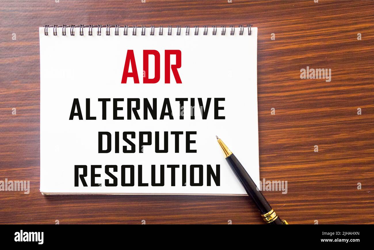 Notizblock mit dem Titel Alternative Streitbeilegung ADR auf dem Tisch. Stockfoto