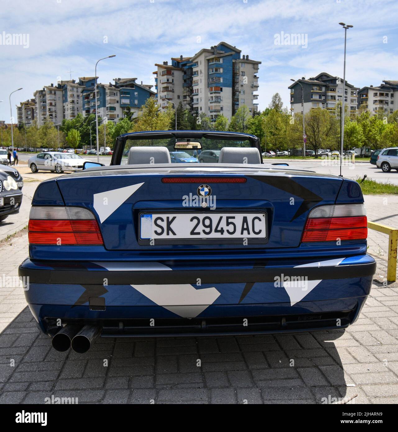 Blick auf das Sportwagen BMW 3 E36 Cabriolet mit Sportfelgen und mit Abziehbildern bedeckt, die auf der Straße geparkt sind. Stockfoto