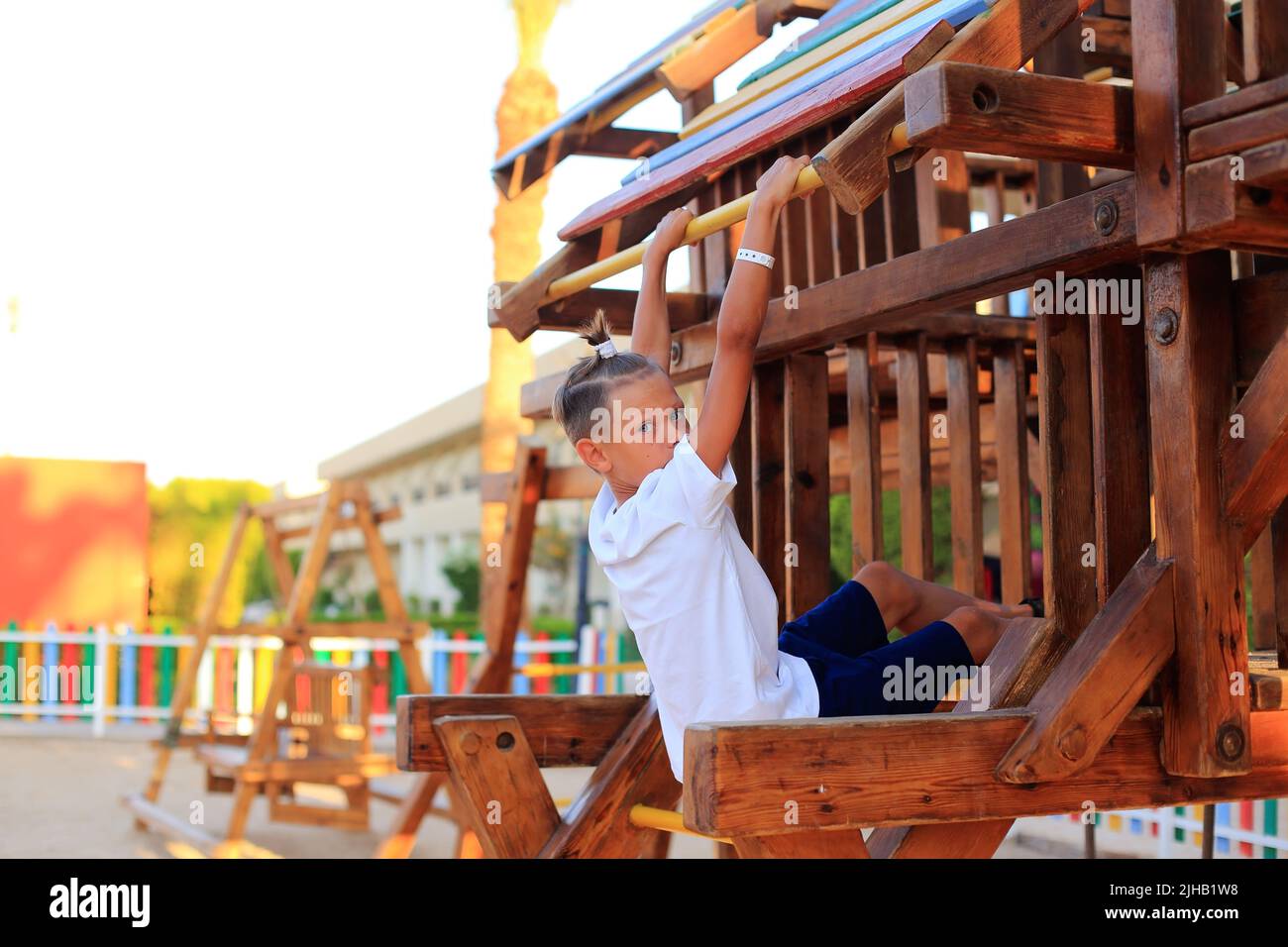 Das Mädchen reitet auf einer Schaukel auf dem Spielplatz. Karussells für Kinder im Freien Stockfoto