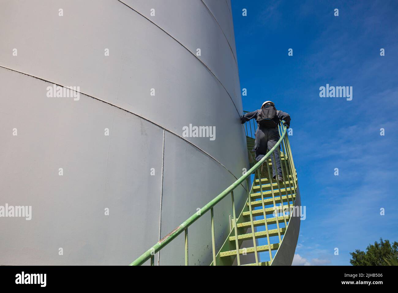 Mann, der die Treppenaufgänge überprüft, Sichtlagerbehälter, Chemikalie. Stockfoto