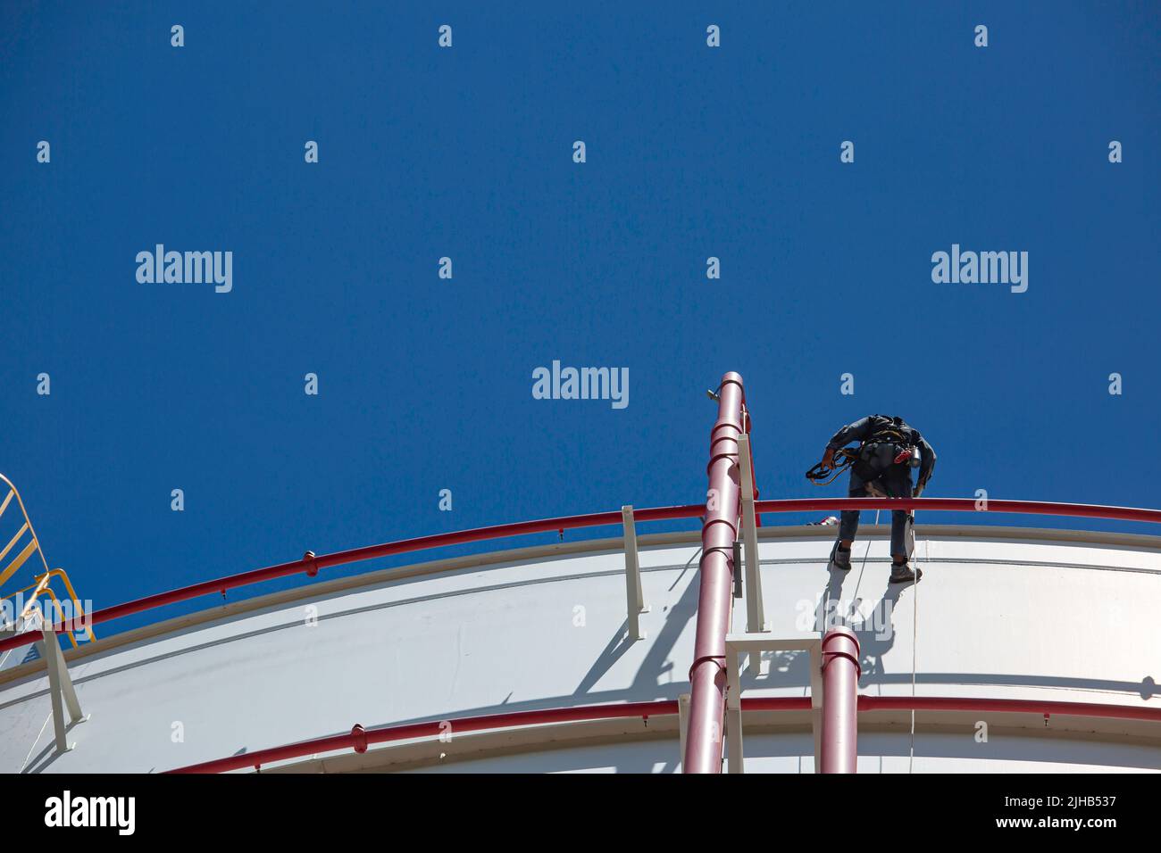 Männlicher Arbeiter in der Höhe Tank Shell Platte Seil Leiter Zugang Sicherheitsprüfung der Dicke Speicher Gas Propan. Stockfoto