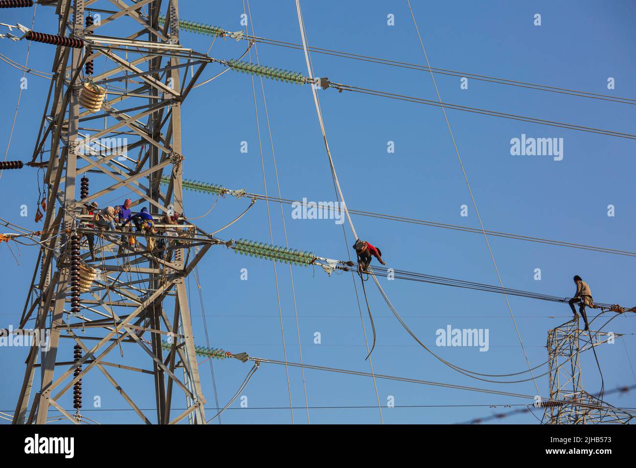 Kraftwerk Bang Pakong, THAILAND - 7. DEZ 2019: Männer gehen auf der Leitung Strom Installation von Hochspannungsmasten die Arbeit in der Höhe Stockfoto