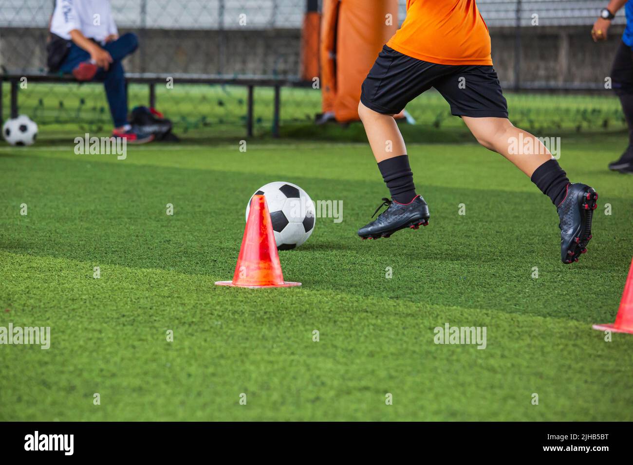 Kinder spielen Kontrolle Fußball Taktik Kegel auf Rasenplatz mit zum Training Hintergrund Training Kinder in Fußball Stockfoto