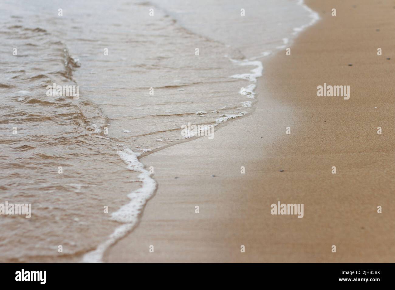 Meereswelle und Sand an einem strand von sanny Stockfoto