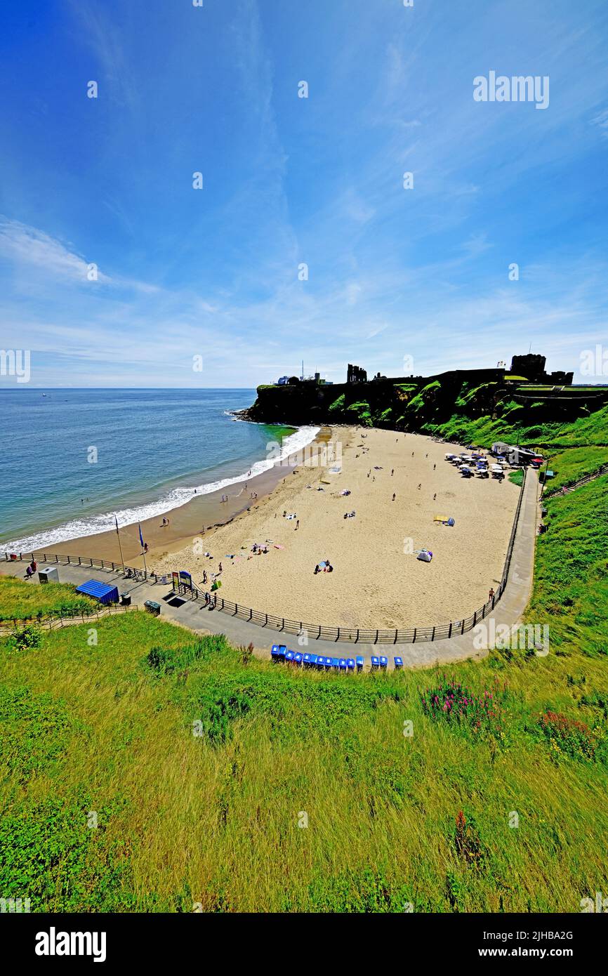 King Edwards Bay Tynemouth mit der Burg und dem Priorat auch Rileys Fish Shack serviert Mid Frame an einem schönen sonnigen Tag mit blauem Himmel Stockfoto