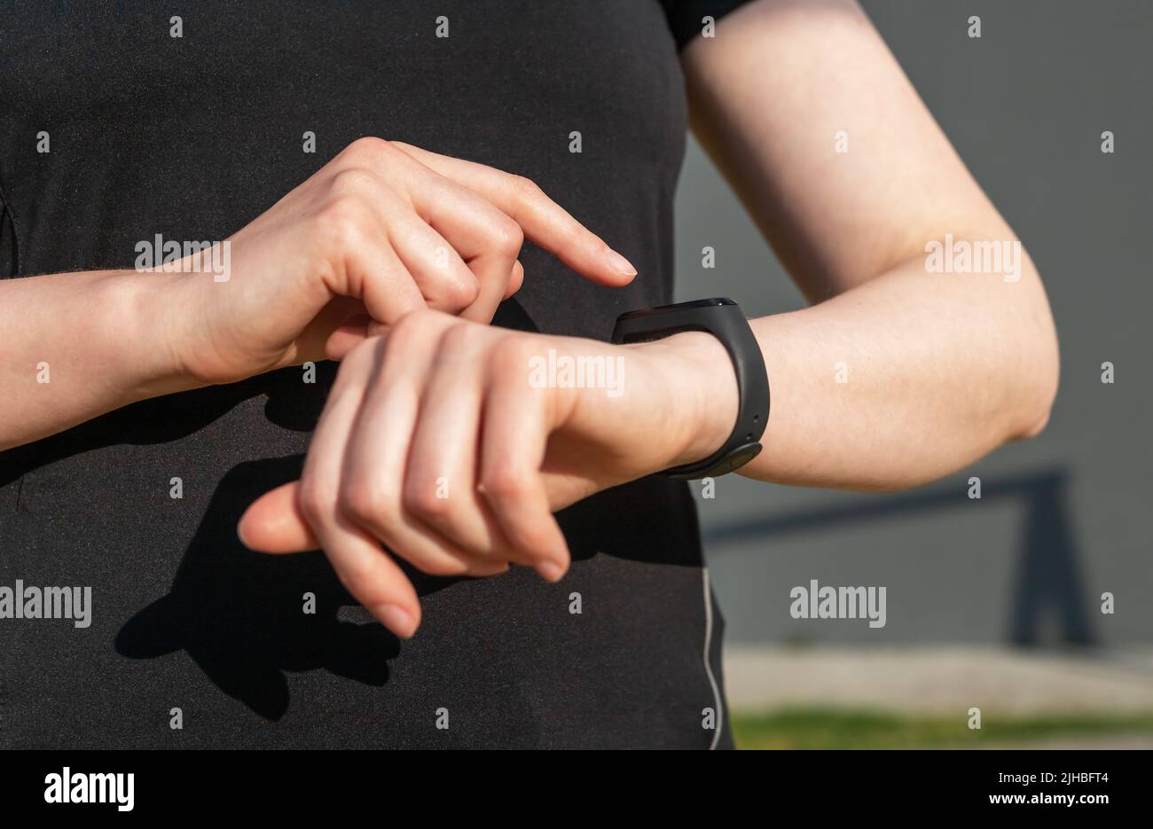 Frau, die Fitness-Tracker für die Schrittzahl oder die Herzfrequenzüberwachung verwendet. Weibliche Hände aus der Nähe. Gesundes Lifestyle-Konzept. Trainingsgerät. Hochwertige Fotos Stockfoto