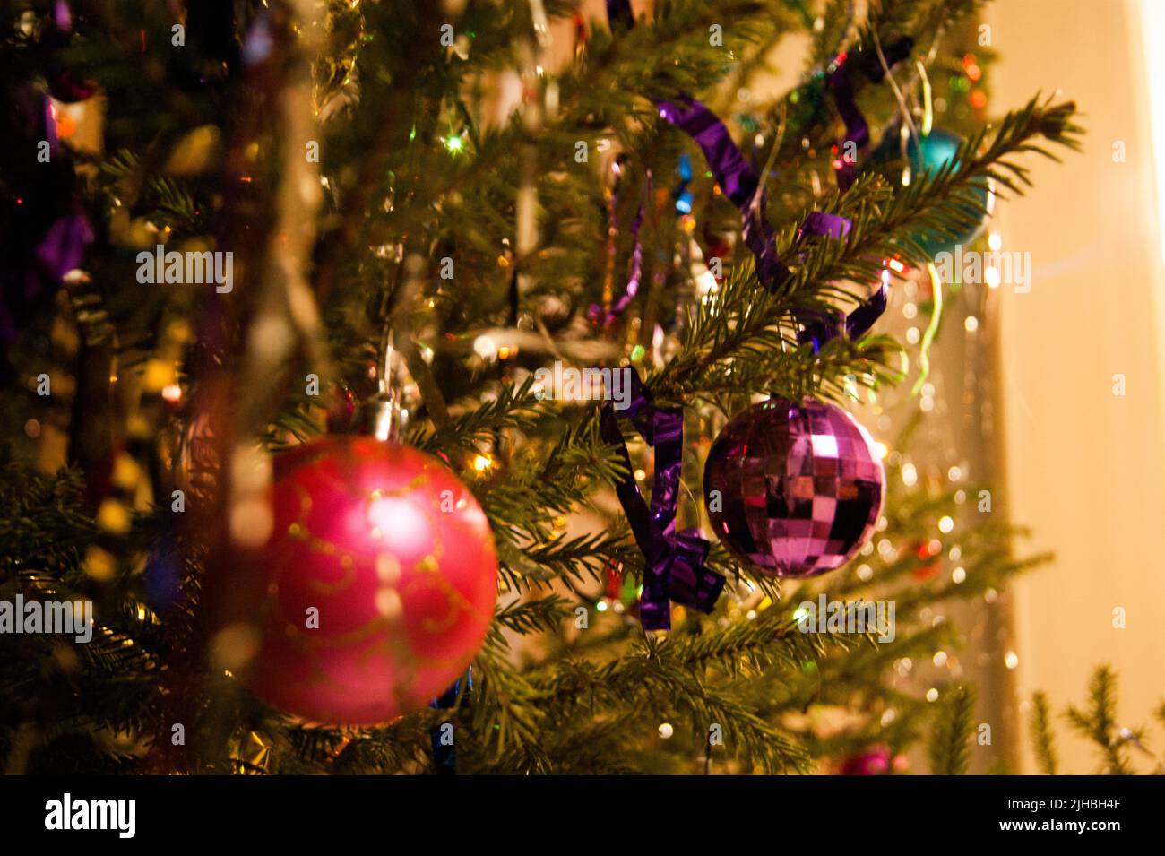 Der Feiertag ist ein neues Jahr oder Weihnachten, auf dem Foto ist eine lebende Tanne mit Spielzeug, Lametta und Perlen geschmückt. Retro. Stockfoto