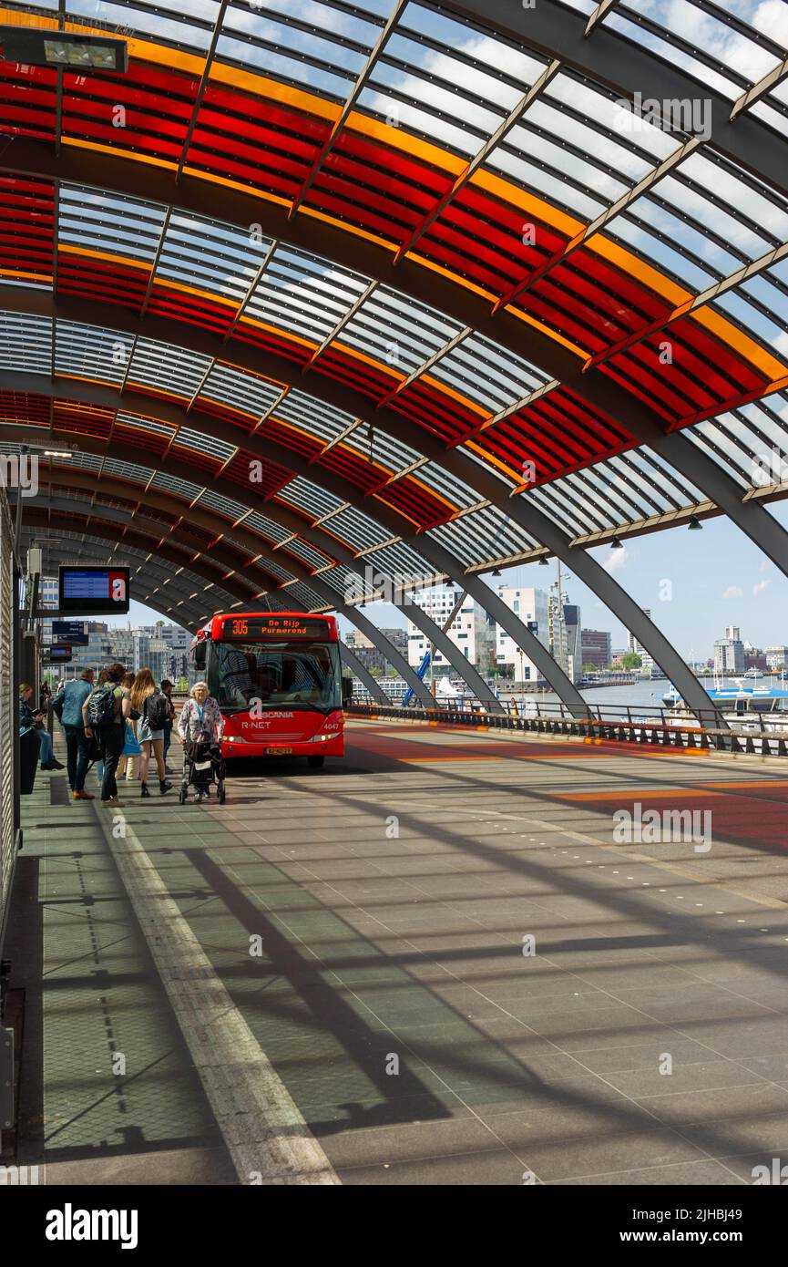 Amsterdamer Hauptbahnhof mit Blick auf den Fluss IJ an einem sonnigen Tag Stockfoto