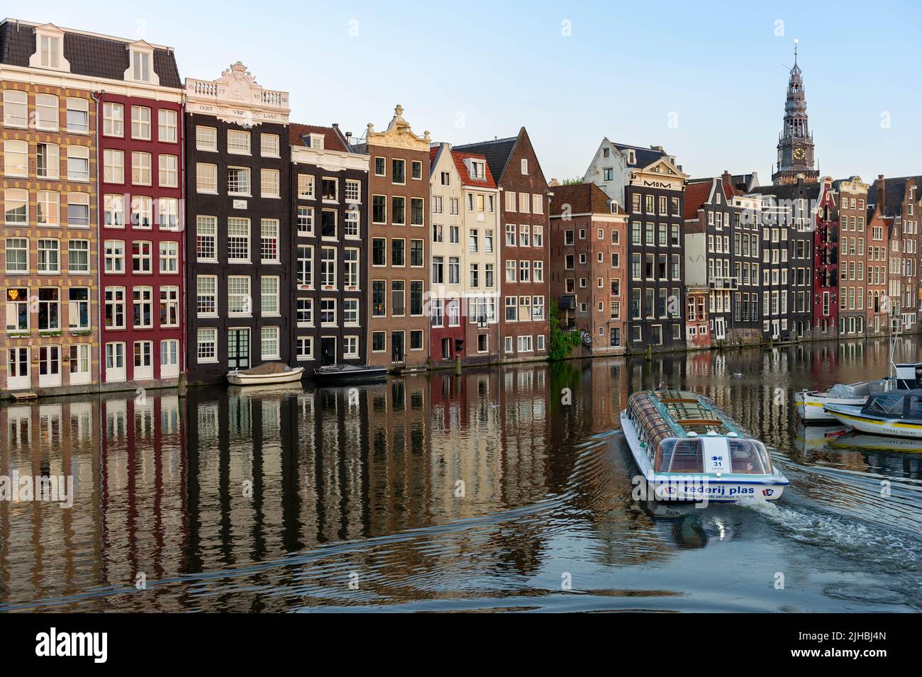 Canal Tours Boot bei Sonnenuntergang auf dem Damrak, Amsterdam Stockfoto