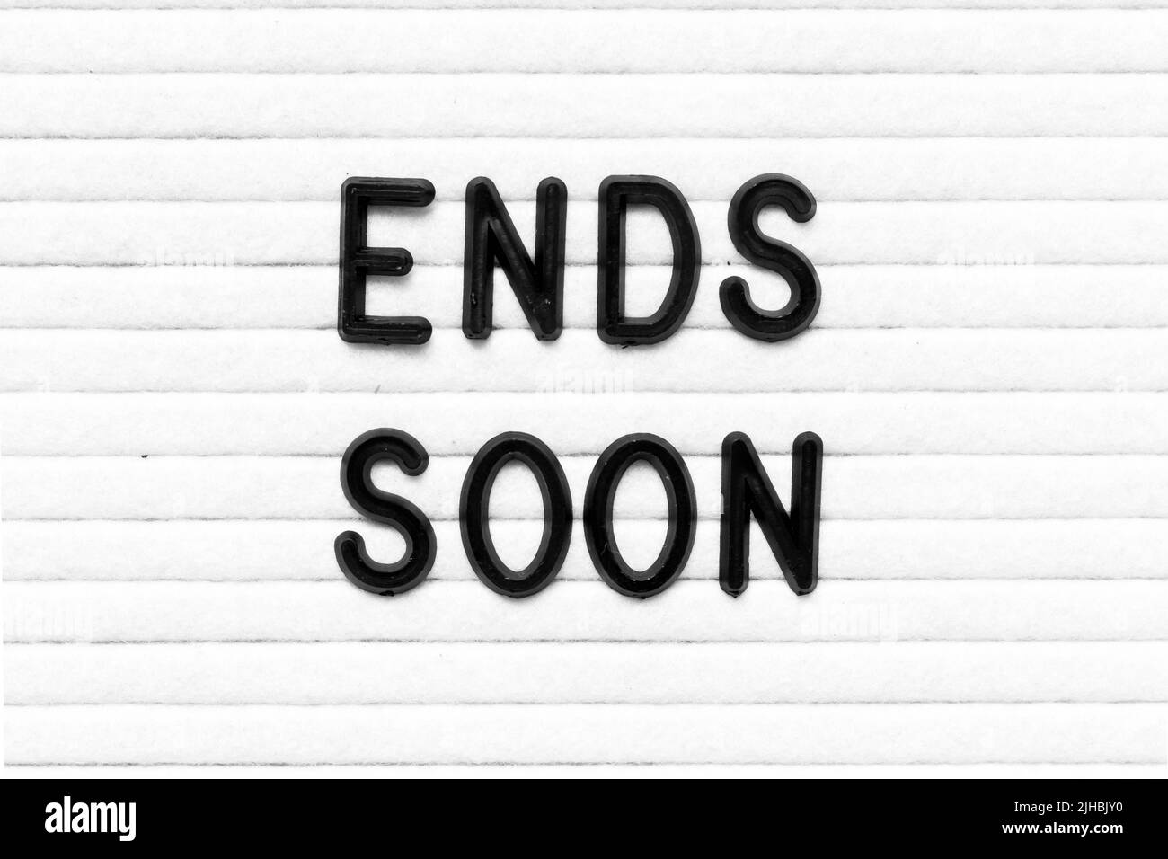 Schwarzer Buchstabe in Wort endet bald auf weißem Filzbrett Hintergrund Stockfoto