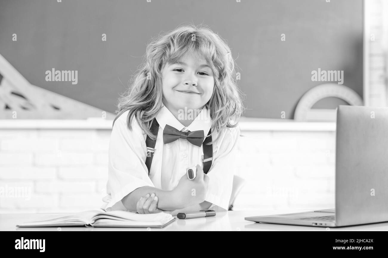 Glückliches Kind Junge in Fliege Studie in der Schule Klassenraum an der Tafel, zurück zur Schule Stockfoto