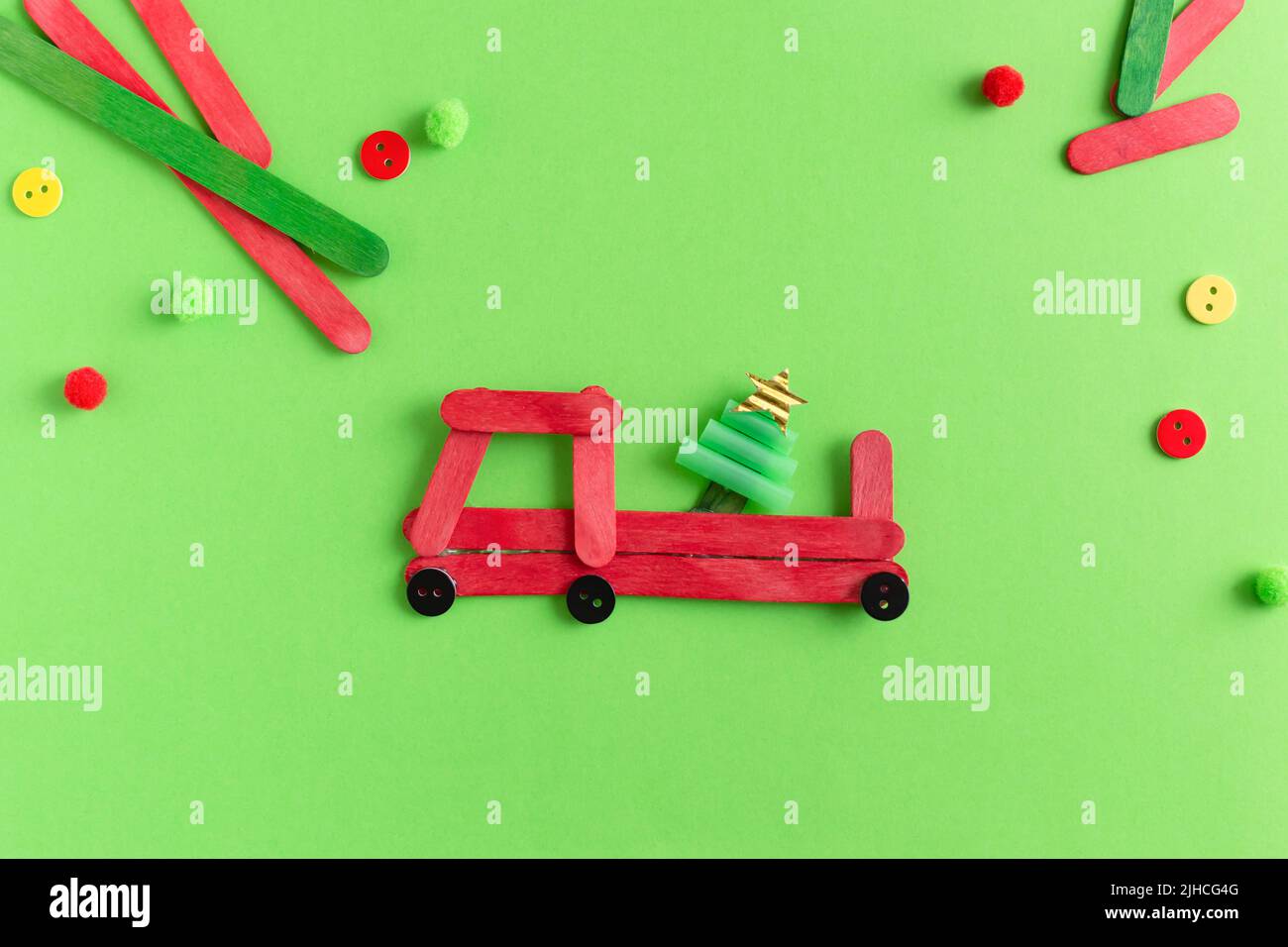 Rotes Auto mit Tannenbaum aus Holzstäben. Handgefertigt. Projekt der Kreativität der Kinder, Kunsthandwerk, Kunsthandwerk für Kinder. Stockfoto