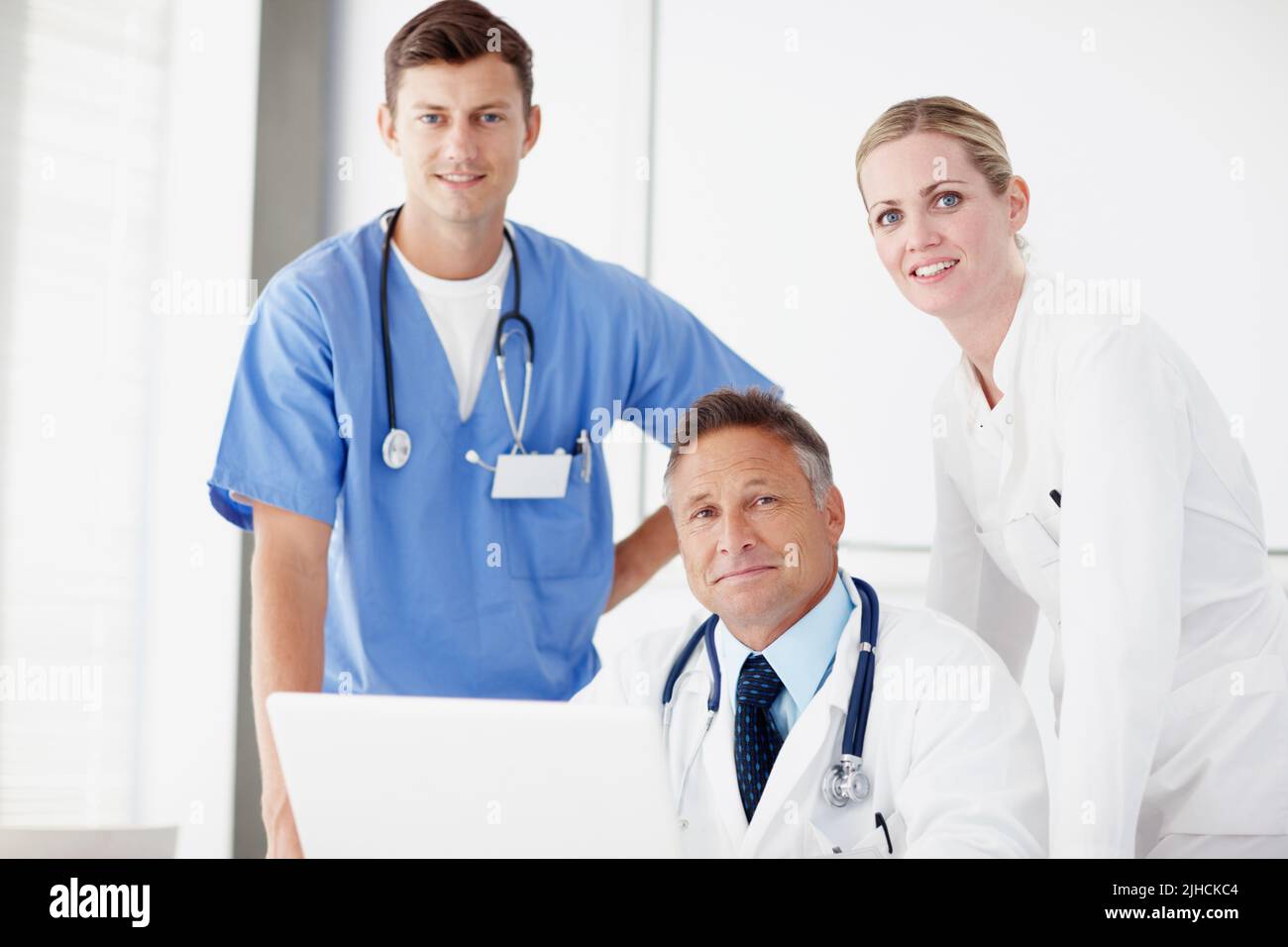 Sie bieten die bestmögliche Gesundheitsversorgung. Porträt von drei medizinischen Fachkräften, die zusammen an einem Laptop arbeiten. Stockfoto