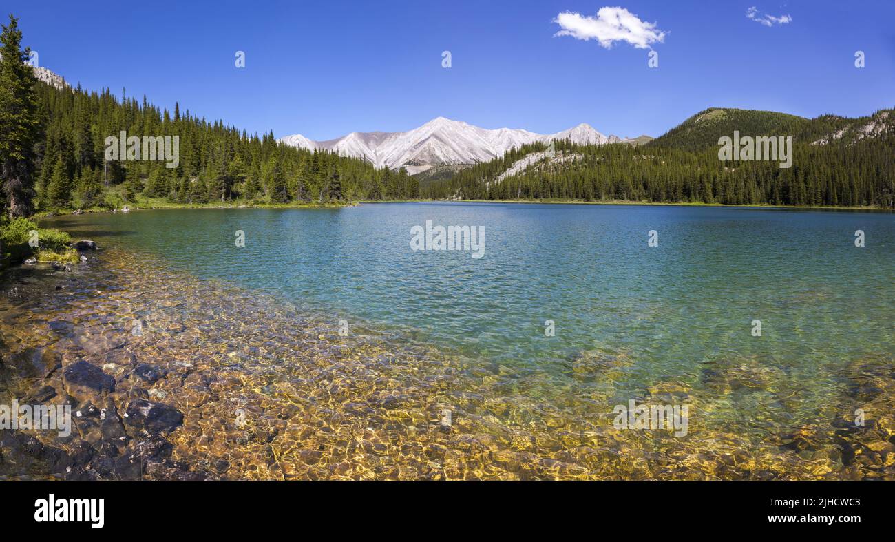 Sawback Lake Green Emerald Water vor den Ranges des Banff National Park mit entfernter Panoramalandschaft auf dem kanadischen Rocky Mountain Peak am Horizont Stockfoto