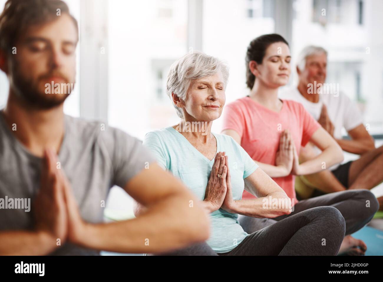 Achtsame Meditation. Eine Gruppe von Menschen meditiert, während sie Yoga praktizieren. Stockfoto