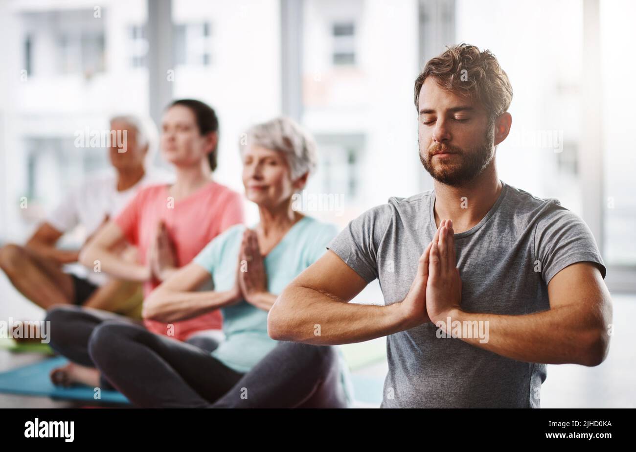 Befreien Sie Ihren Geist. Eine Gruppe von Menschen meditieren, während sie Yoga praktizieren. Stockfoto
