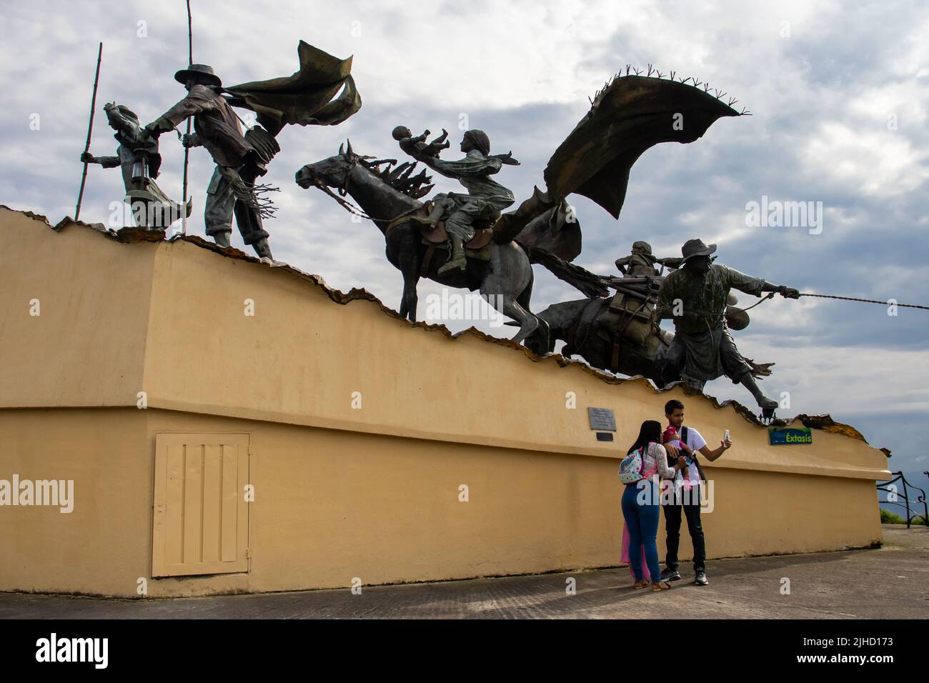 MANIZALES, KOLUMBIEN - MAI 2022: Touristen am Monument für die Kolonisatoren, das der Künstler Luis Guillermo Vallejo mit dem Sandbronzeguss geschaffen hat Stockfoto