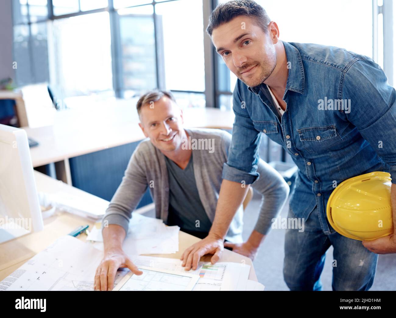 Wenn Sie es träumen können, dann entwerfen Sie es. Zwei Architekten arbeiten zusammen an einem Bauplan mit Hilfe eines digitalen Tablets. Stockfoto