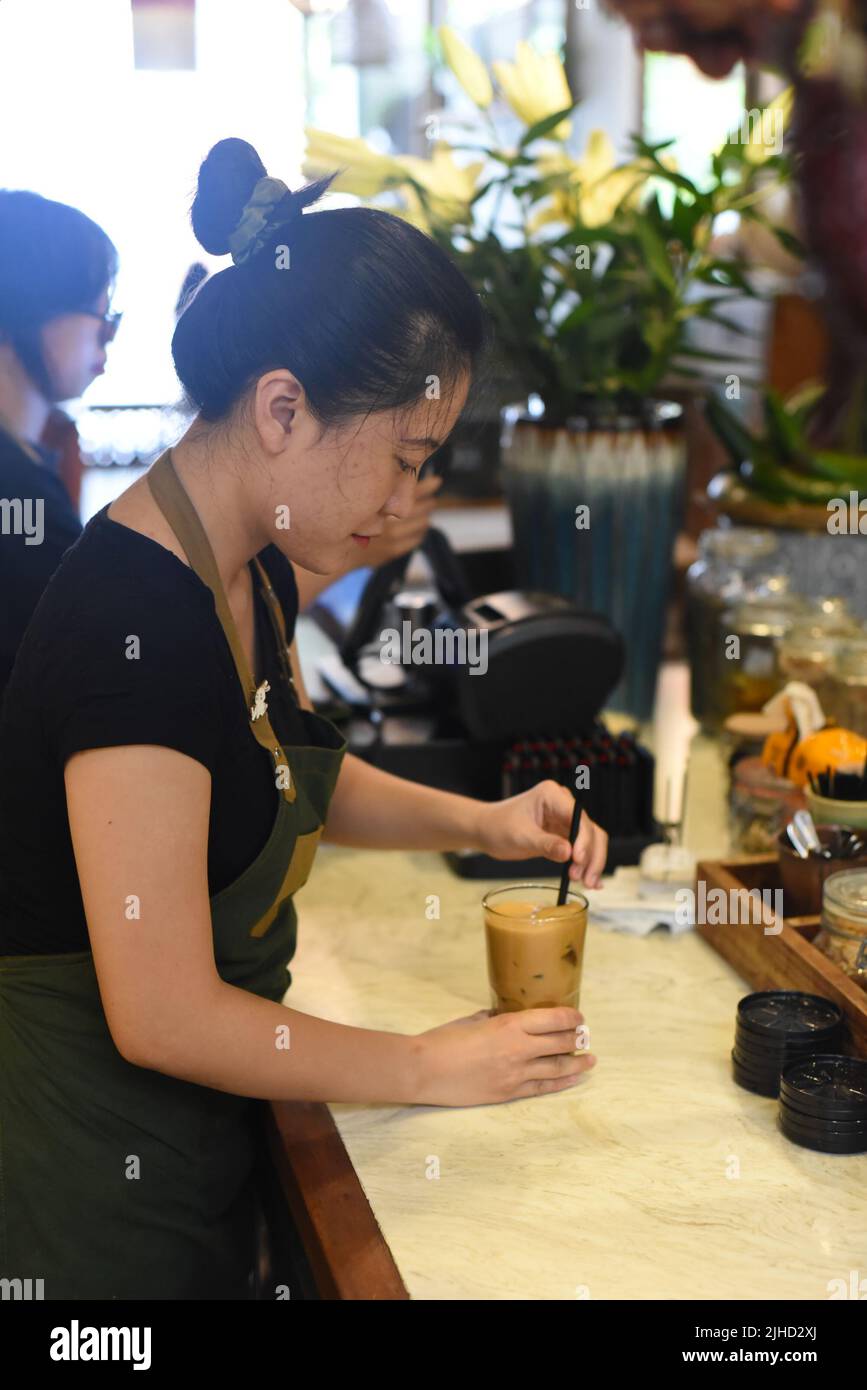 Vietnamesische Kellnerin, die in einem Café Kaffee zubereitet Stockfoto