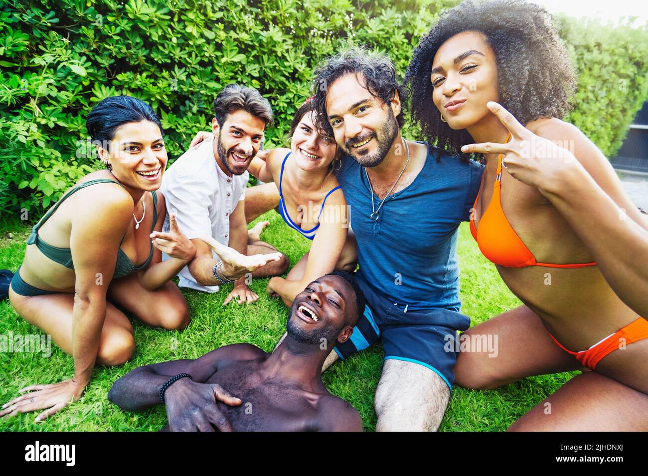 Multiethnische Gruppe von jungen Menschen im Badeanzug, die im Garten im Garten Selfies machen - Menschen, Freundschaft und Zweisamkeit Konzept Stockfoto