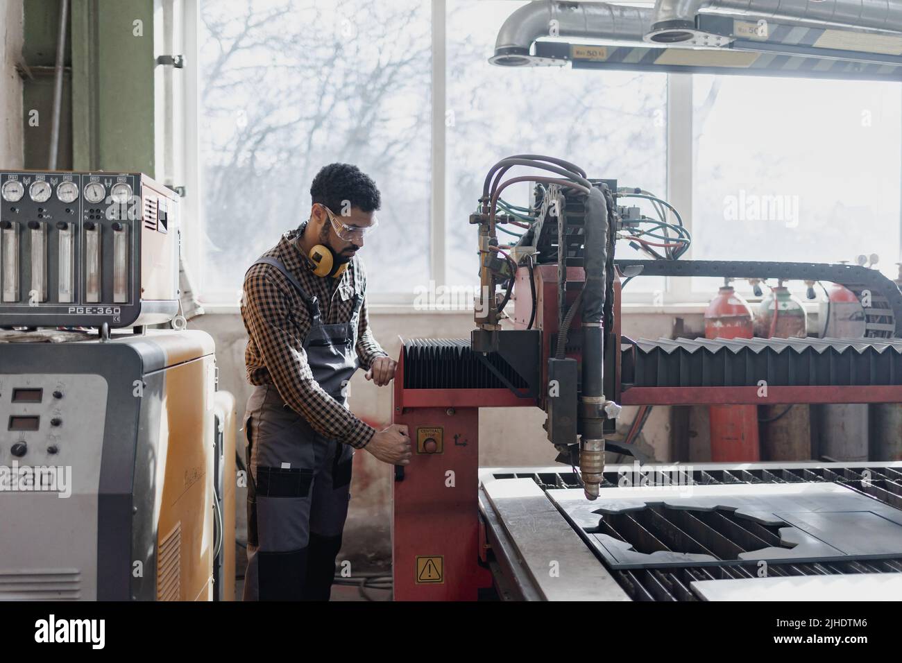 Porträt eines Arbeiters in der Schwerindustrie mit Sicherheitskopfhörern und in der Industriefabrik Stockfoto