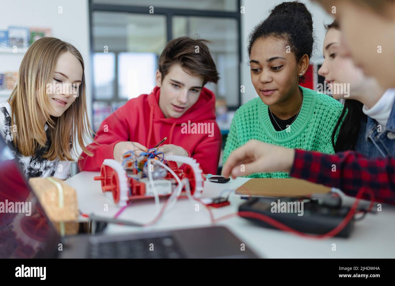 Eine Gruppe von Schülern, die elektrische Spielzeuge und Roboter im Roboterunterricht bauen und programmieren Stockfoto