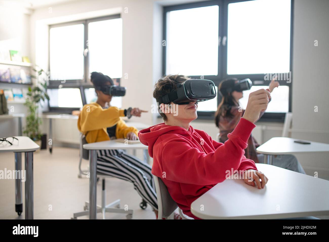 Teenager, die in der Schule im Informatikunterricht eine Virtual-Reality-Brille tragen Stockfoto