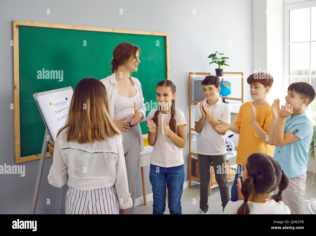 Kinder in der Grundschule lernen in kreativem Unterricht, indem sie mit dem Lehrer spielen. Stockfoto