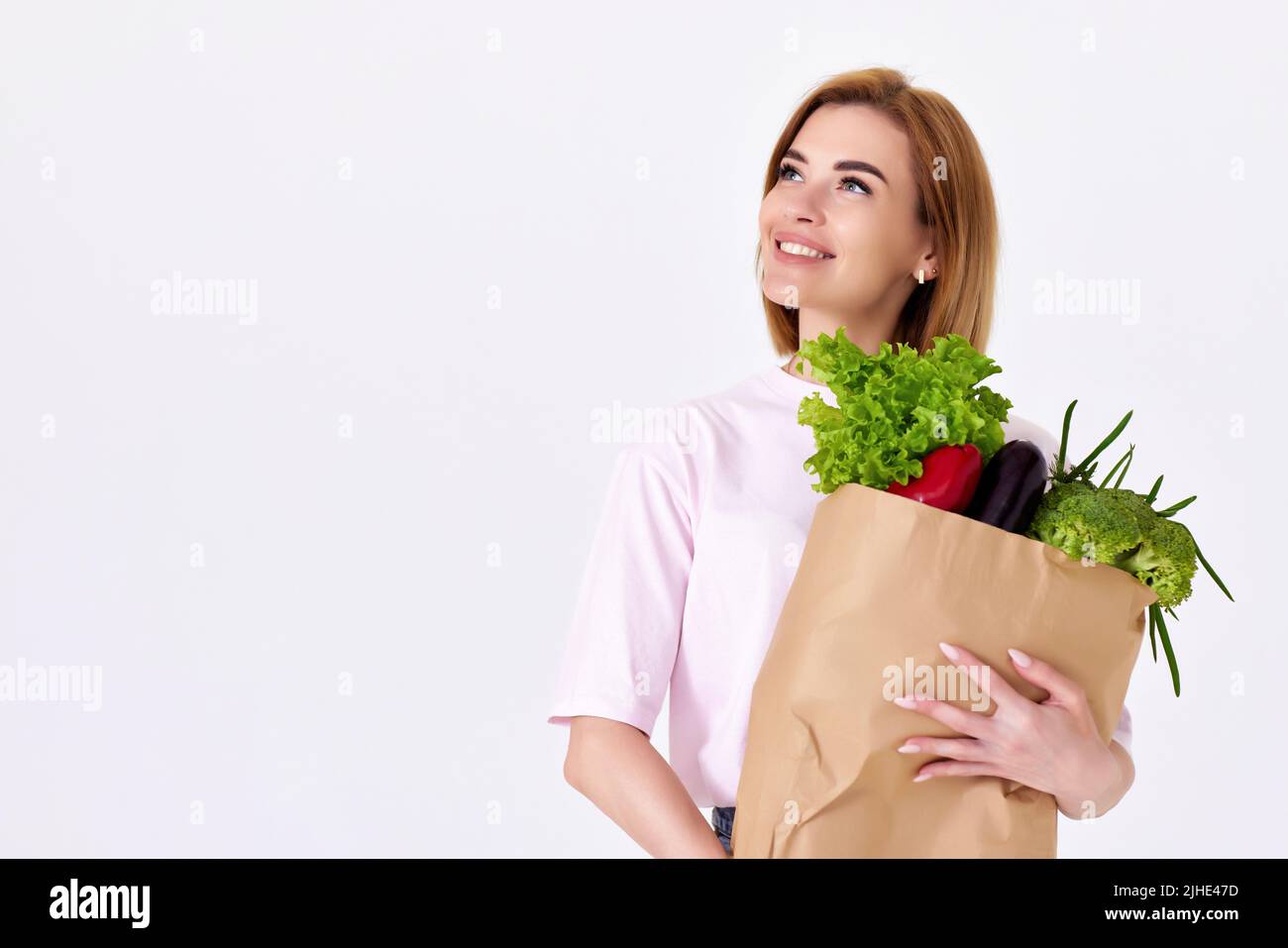 kaukasische Frau hält Papiertüte mit Gemüse Stockfoto