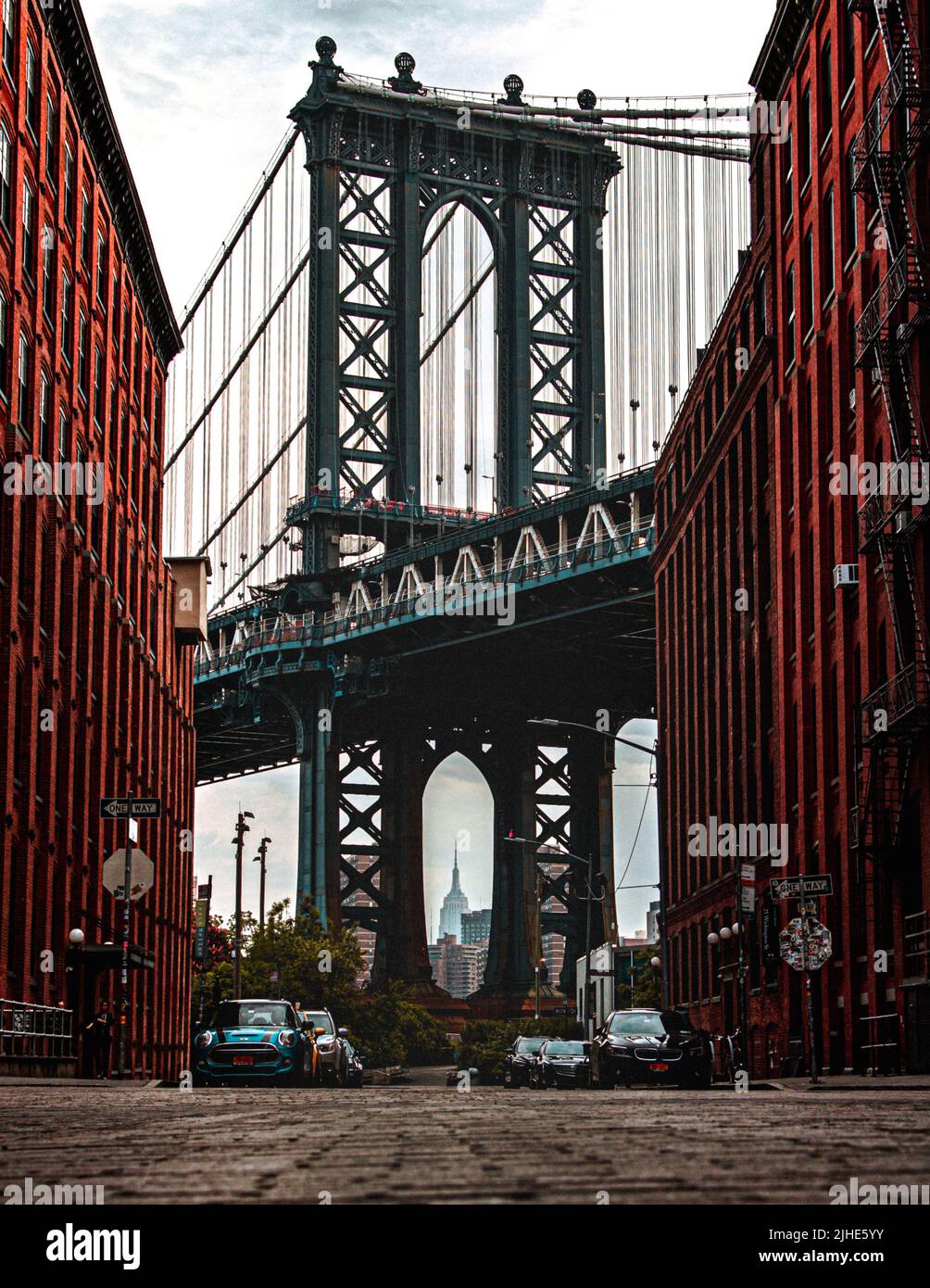 Ikonisches Foto von Dumbo Manhatten. Zwischen den Pillern der Manhetten-Brücke ist das Empire State Building zu sehen. Stockfoto