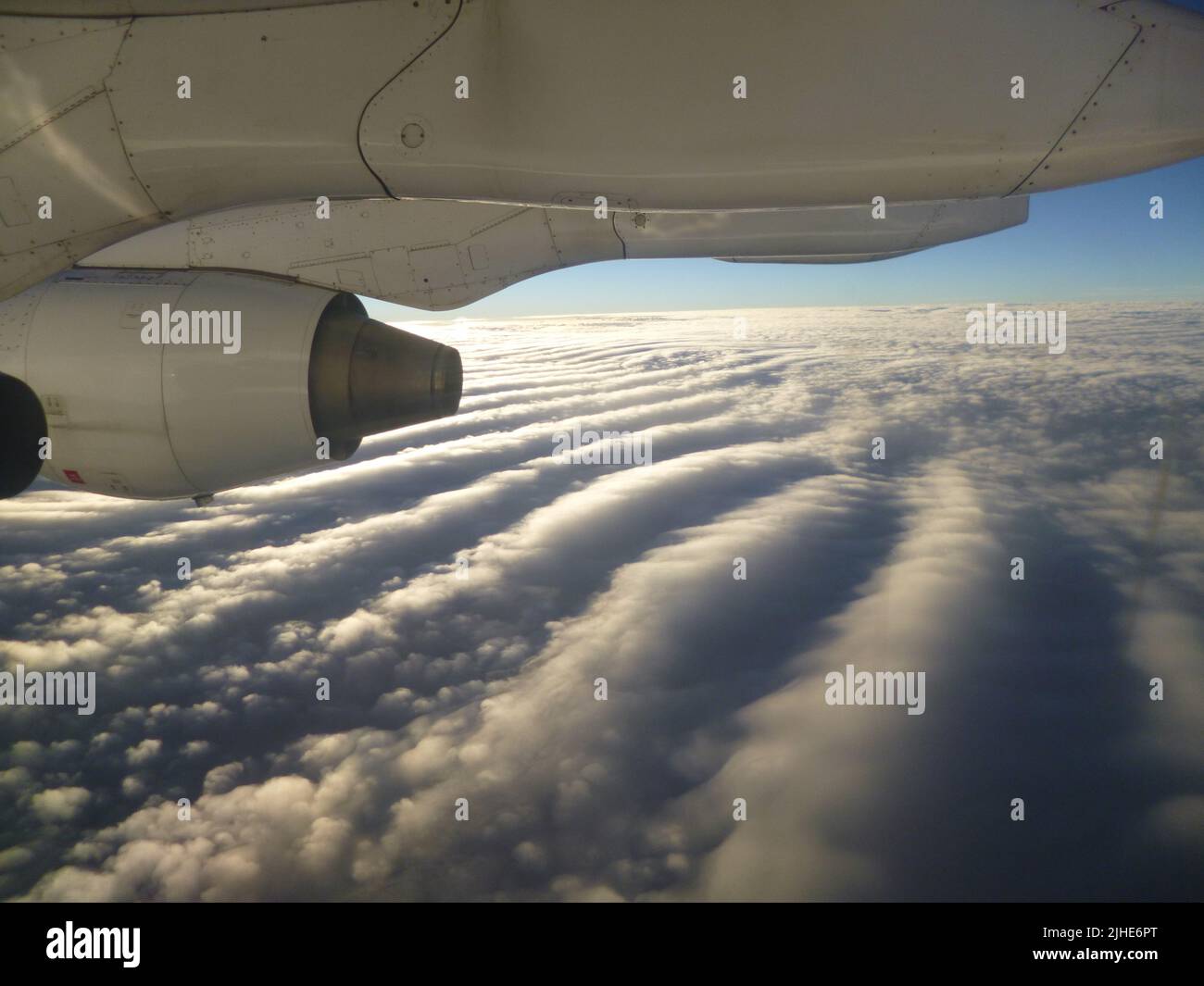 Eine Nahaufnahme eines Flugzeugmotors über den flauschigen Wolken Stockfoto