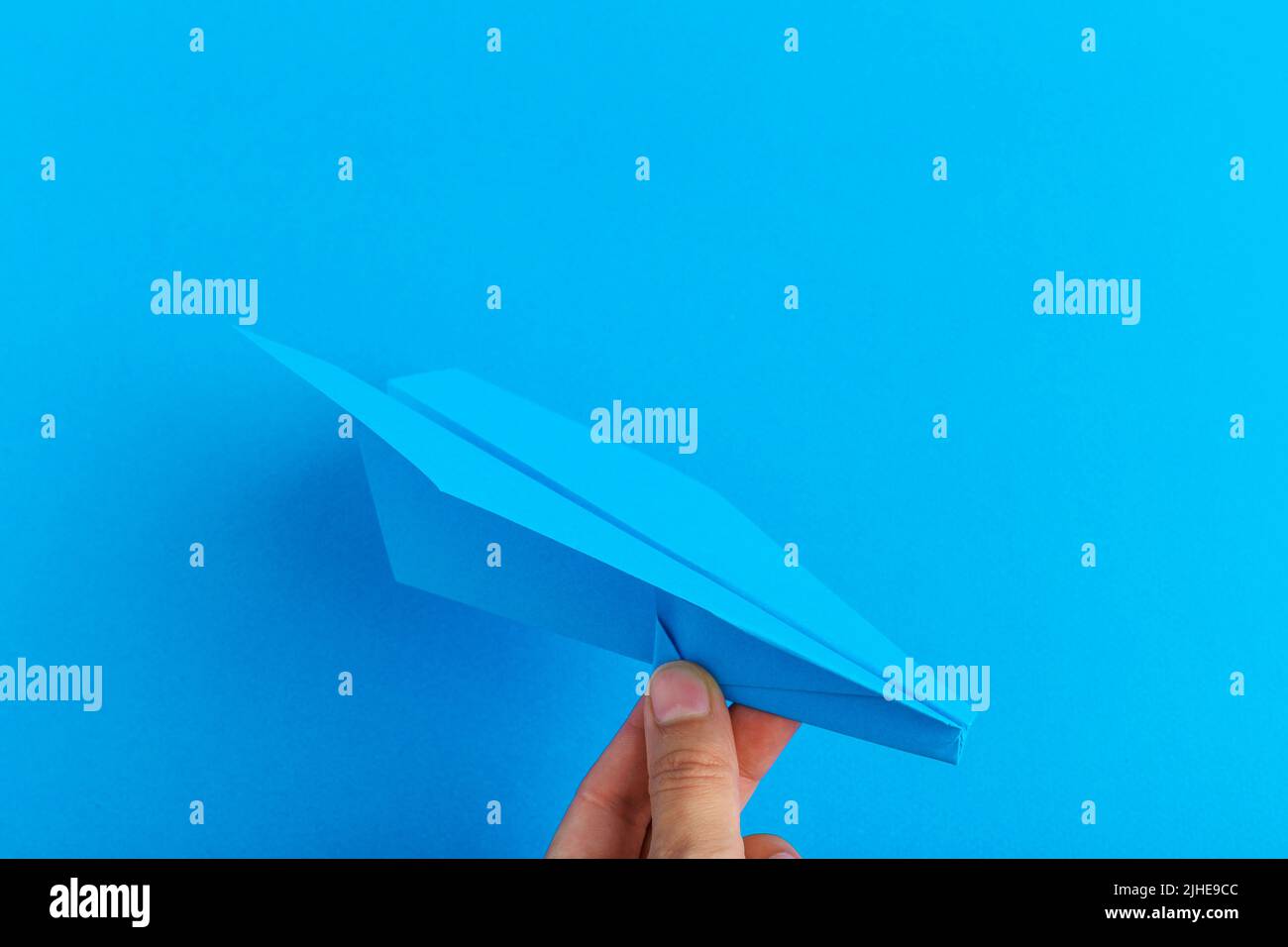 Paper Plane auf hellen Hintergrund bestand in der menschlichen Hand. Reise und Tourismus Konzept Stockfoto