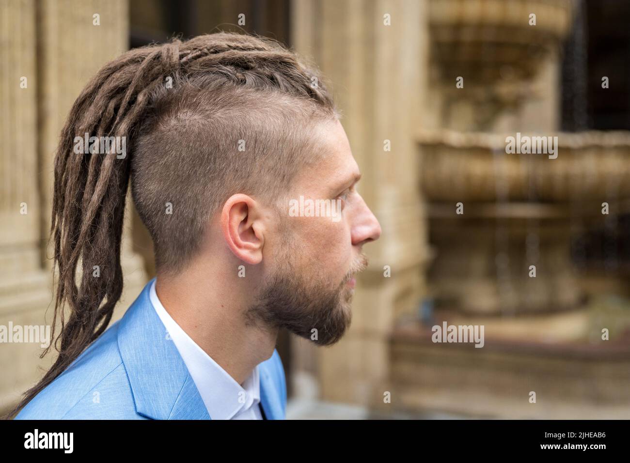 Porträt im Profil eines kaukasischen Mannes mit Dreadlocks Stockfoto