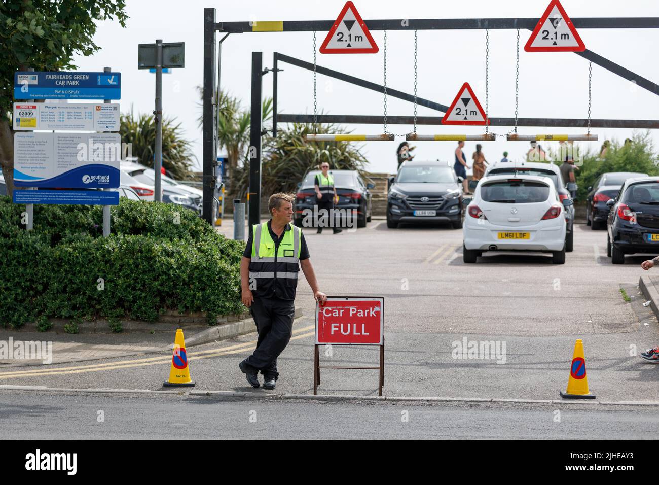 Keine Parkplätze am Strand. Ein Parkwächter steht an einem heißen Sommertag während der Hitzewelle des Sommers 2022 an einem Parkplatz mit vollem Schild Stockfoto