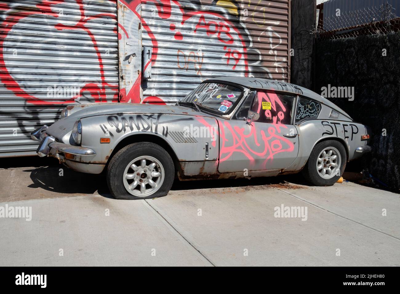 STADTLANDSCHAFT. Eine graffierte und reckte Jaguar Limousine in der Roebling Street in Williamsburg, Brooklyn, New York. Stockfoto