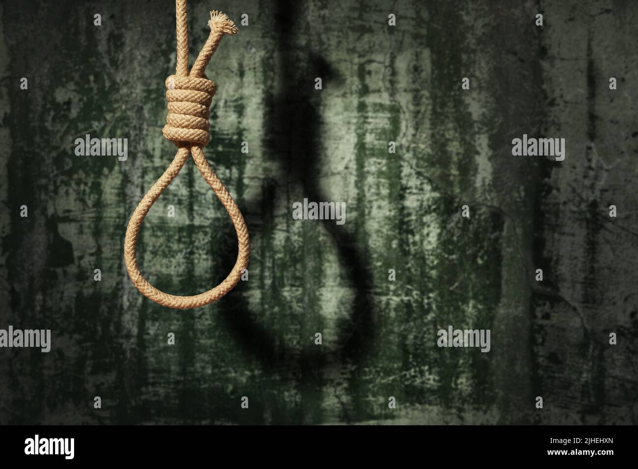Selbstmordkonzept. Schlinge mit Schatten auf dunklem Wandhintergrund Stockfoto