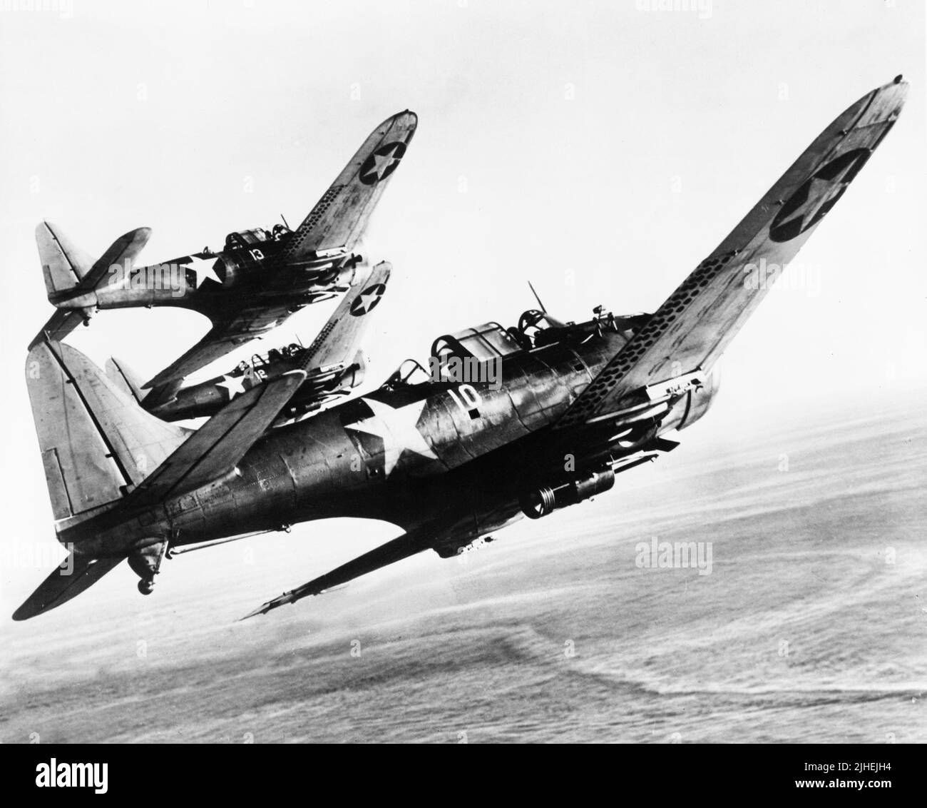Vintage-Foto um 1942 von einem Flug der amerikanischen Douglas SBD Dauntless Tauchbomber im Flug. Sie diente während des Pazifikkrieges gegen das Japanische Reich mit dem US Marine Corps und der US Navy auf Flugzeugträgern Stockfoto