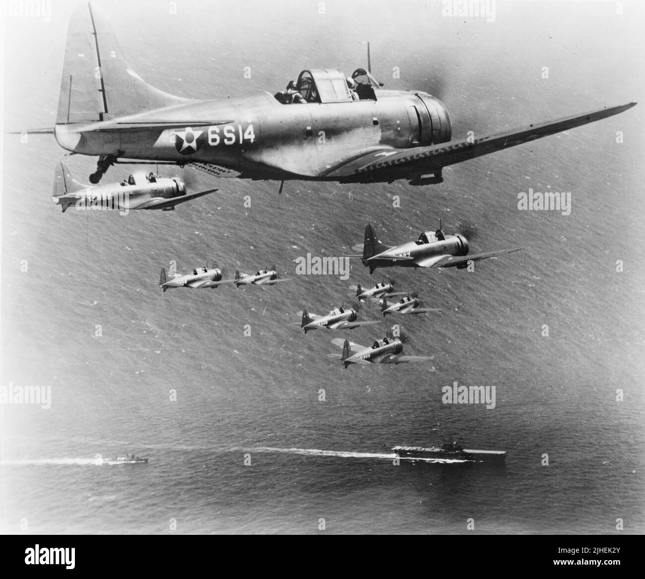 Vintage-Foto um 1941 von einem Flug der amerikanischen Douglas SBD Dauntless Tauchbomber von Scouting Squadron Six (VS-6) auf dem Flug über die USS Enterprise. Sie diente während des Pazifikkrieges gegen das Japanische Reich mit dem US Marine Corps und der US Navy auf Flugzeugträgern Stockfoto