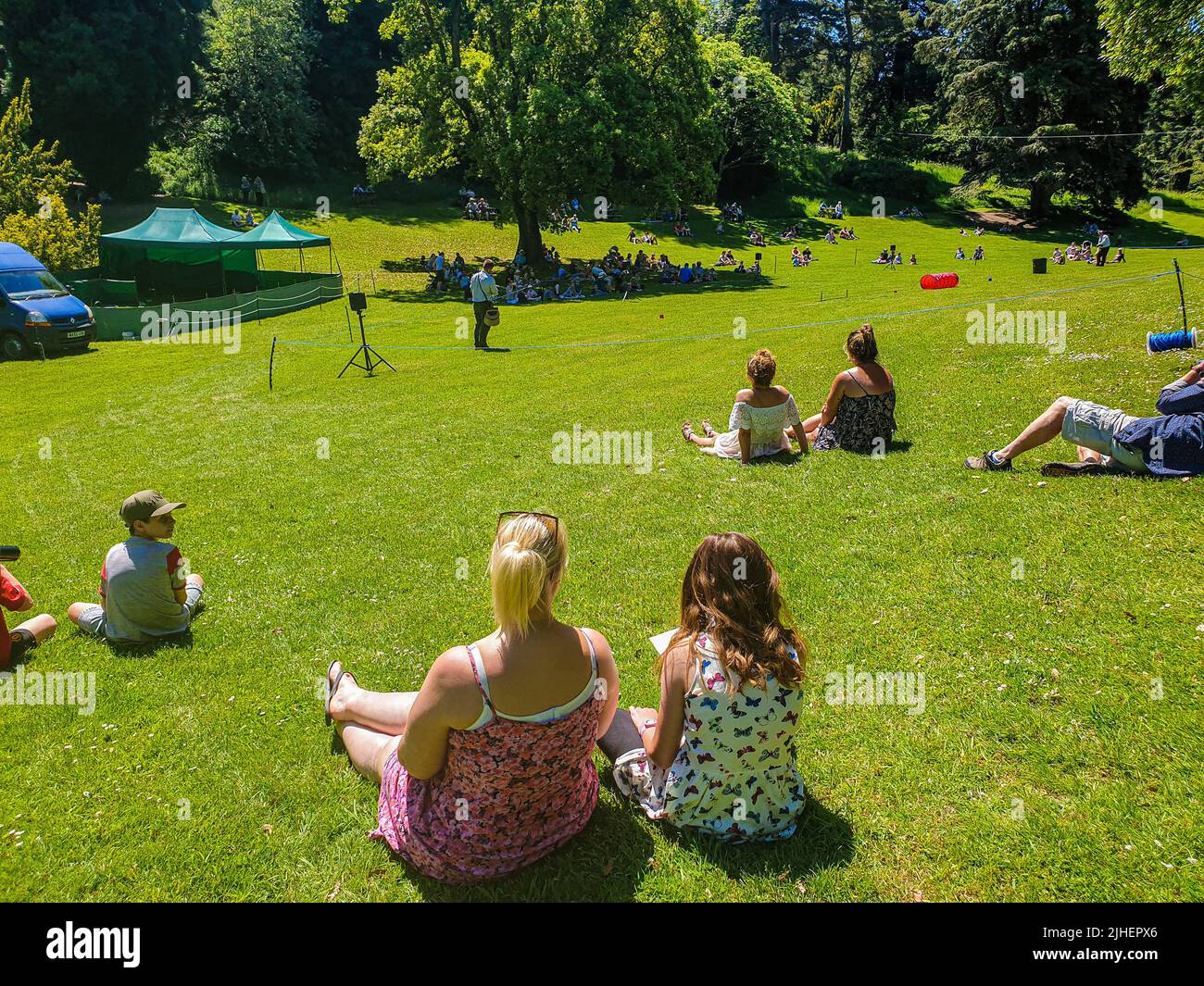 Die Menschen sitzen auf einem sonnigen Hügel, um eine Greifvogelschau in Ledbury, Herefordshire, Großbritannien, zu beobachten Stockfoto