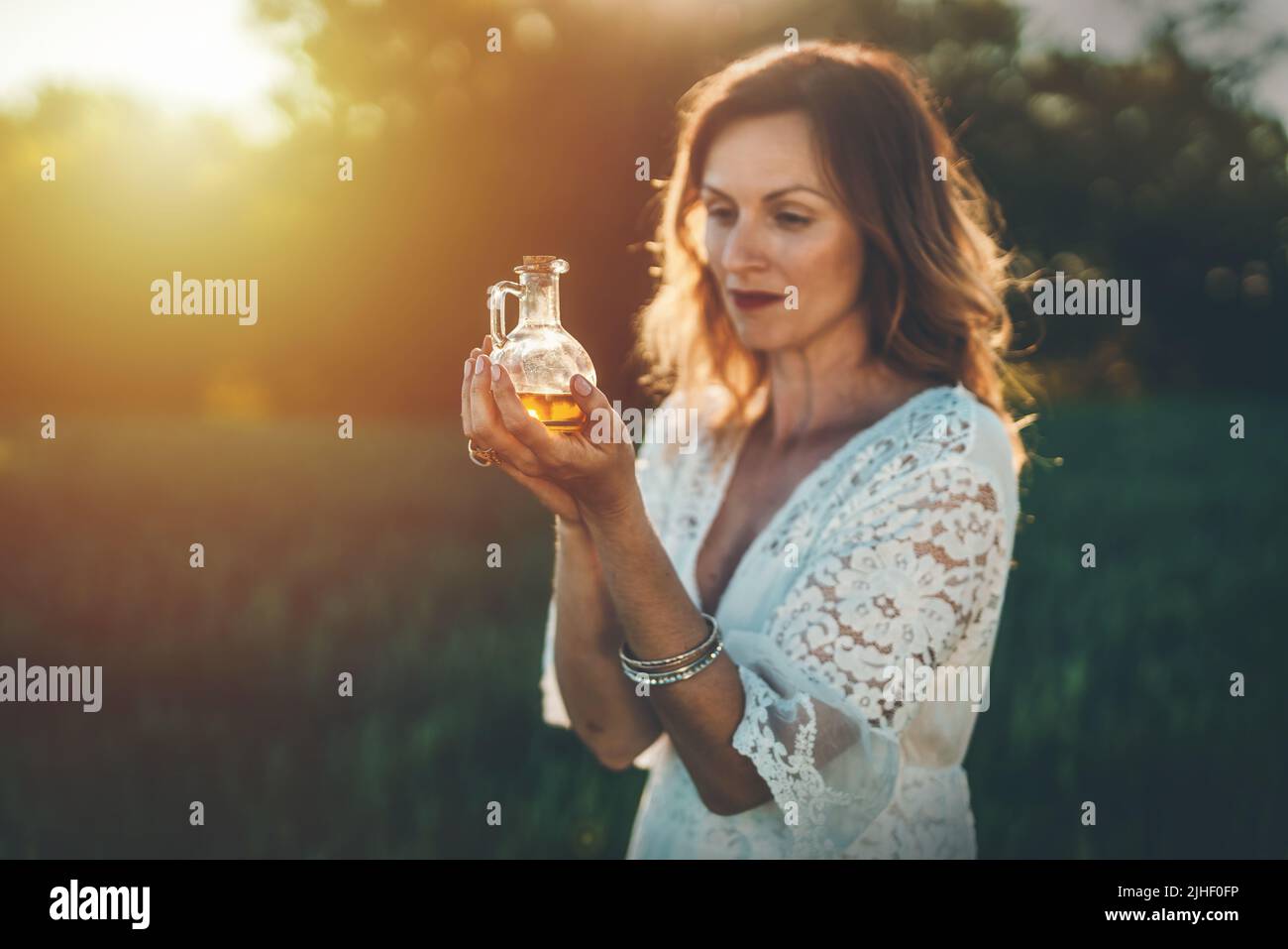 Frau mit einer Flasche Öl. Konzept der alternativen Medizin und Kräuter. Stockfoto